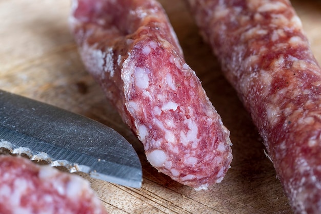 I pezzi di salsiccia a fette giacciono su un tagliere