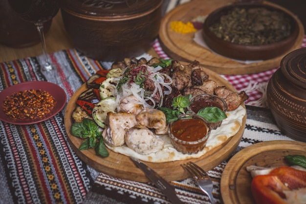 I piatti della tavola riccamente imbanditi della cucina georgiana sono ricchi di cibi deliziosi, frutta e carne arrostita