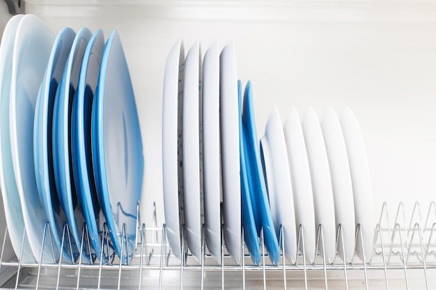 I piatti puliti stanno in un cassetto per asciugare i piatti in cucina