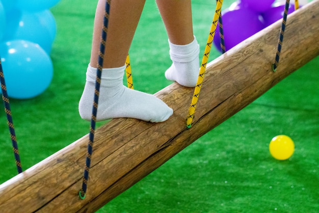 I piedi dei bambini al parco giochi con ponte oscillante.