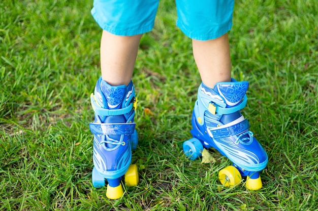 I piedi dei bambini in pattini a rotelle in primo piano, concept sport, giochi all'aperto, giochi attivi