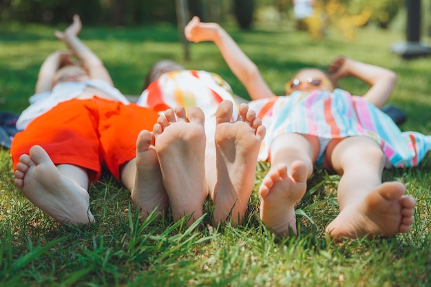 I piedi dei bambini sul focuschild selettivo dell'erba verde