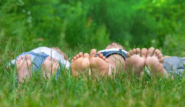 I piedi dei bambini sull'erba verde del parco Focus selettivo a piedi nudi