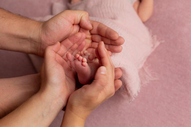 i piedi del bambino nelle mani del bambino più grande e della mamma