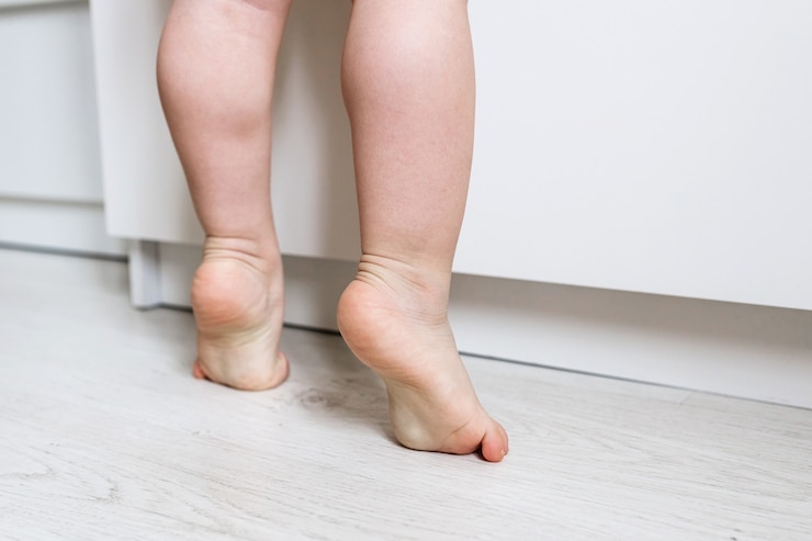 Foto i piedi del bambino nudo si chiudono in piedi sulle punte dei piedi. bambino in punta di piedi. sviluppo di un bambino sano. piccola ballerina fin dall'infanzia