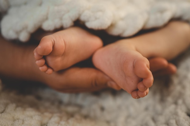 I piedi del neonato su una coperta bianca