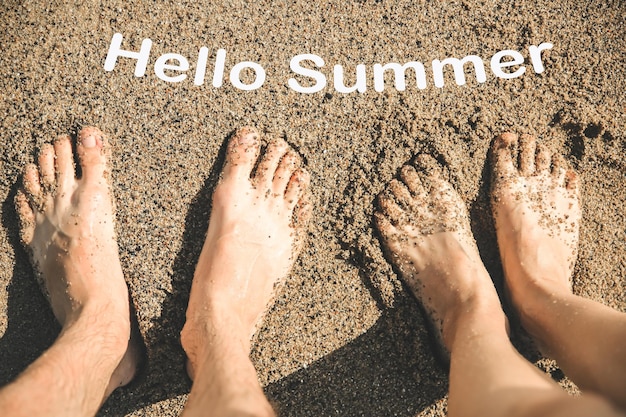 I piedi dell'uomo e della donna nell'acqua Romantica foto estiva in spiaggia Concetto di vacanza Viaggio al mare Oceano caldo Dita dei piedi nella sabbia