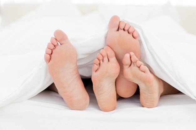 I piedi della famiglia nel letto