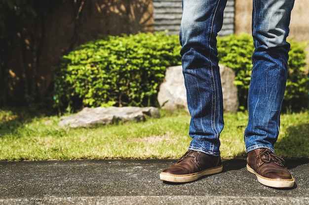 I piedi di un uomo solo in piedi a terra con i jeans