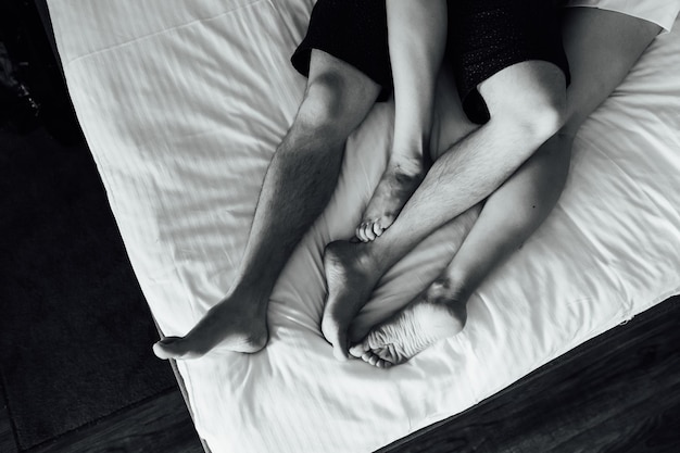 I piedi di una giovane coppia eterosessuale che si rilassa a letto.