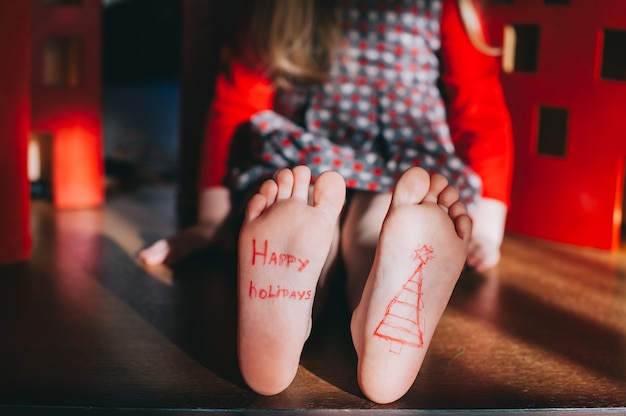 i piedi nudi del bambino sul pavimento di legno. Concetto di celebrazione di Natale