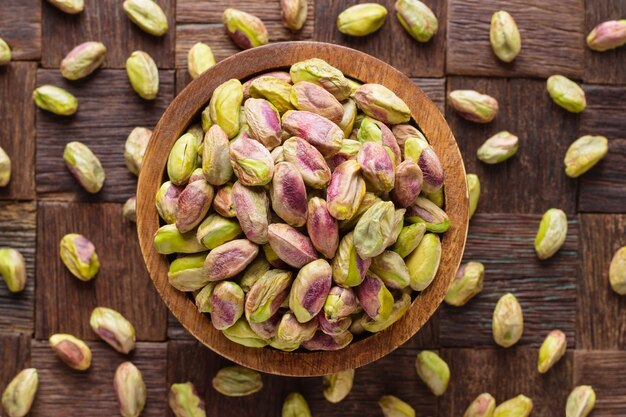 I pistacchi sbucciati in una ciotola sulla tavola di legno.