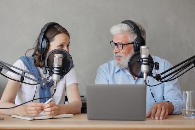 I podcaster di sesso femminile e maschile registrano contenuti audio nel programma di notizie sui social media dello studio audio alla radio