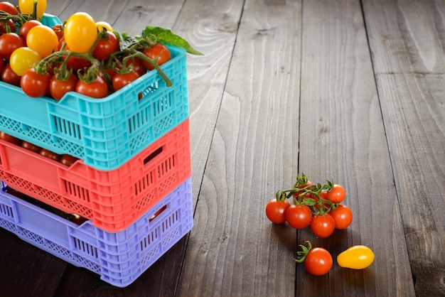 I pomodori maturi freschi sono nelle scatole sulla tavola di legno di broun