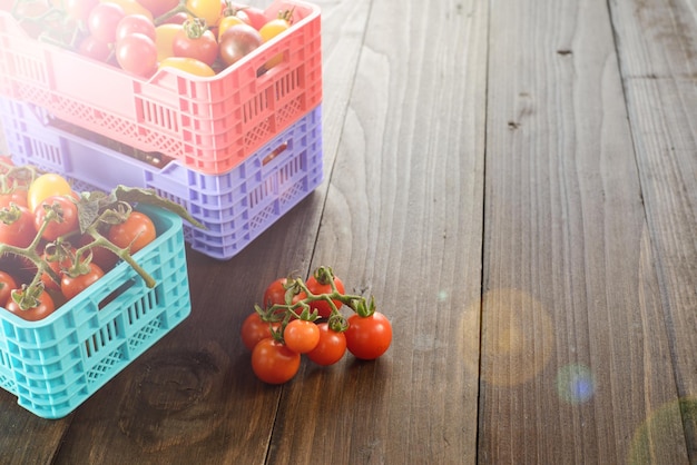 I pomodori maturi freschi sono nelle scatole sulla tavola di legno di broun