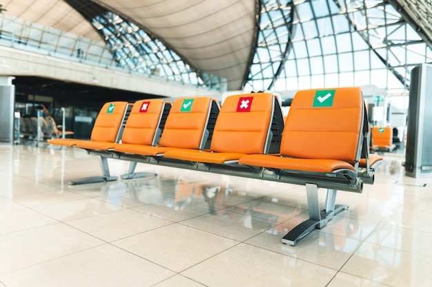 I posti pubblici arancioni in aeroporto sono distanziati all'interno del terminal dell'aeroporto