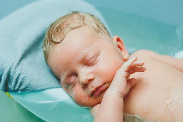 I primi bagni dei bambini Prendersi cura di un neonato Bagnare un bambino in una vasca da bagno Un neonato si sta bagnando in acqua