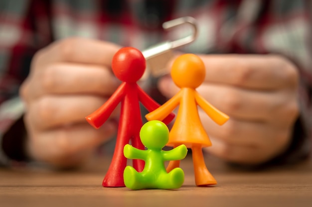 I primi problemi della giovane famiglia figurine colorate sul tavolo con lucchetto Foto concettuale di crisi di conflitto