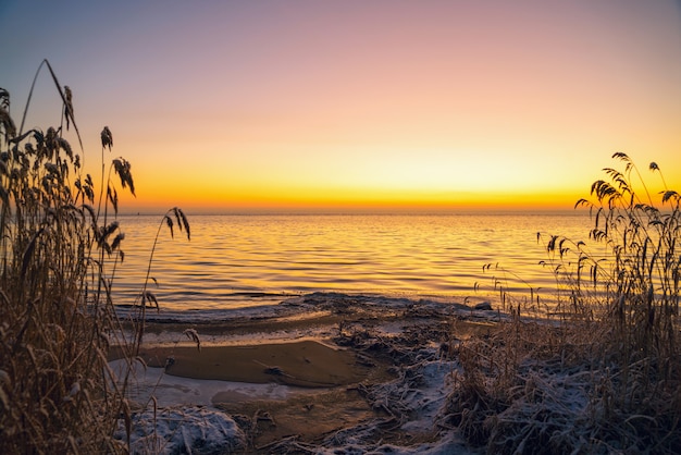 I primi raggi del sole sul lago Ladoga al mattino in inverno.