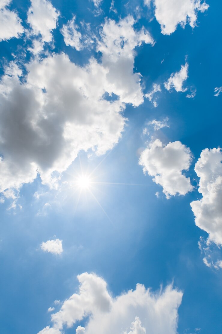 I raggi di luce del sole dal sole sul bel cielo azzurro con le nuvole di pioggia si stanno muovendo