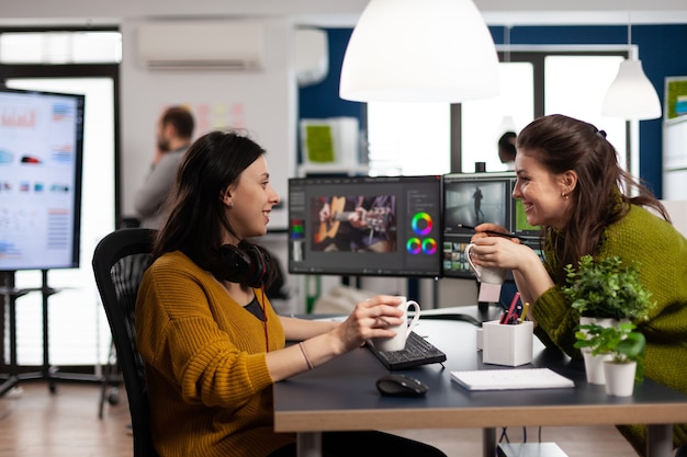 I redattori video dei colleghi discutono davanti al PC che lavorano per i filmati del cliente