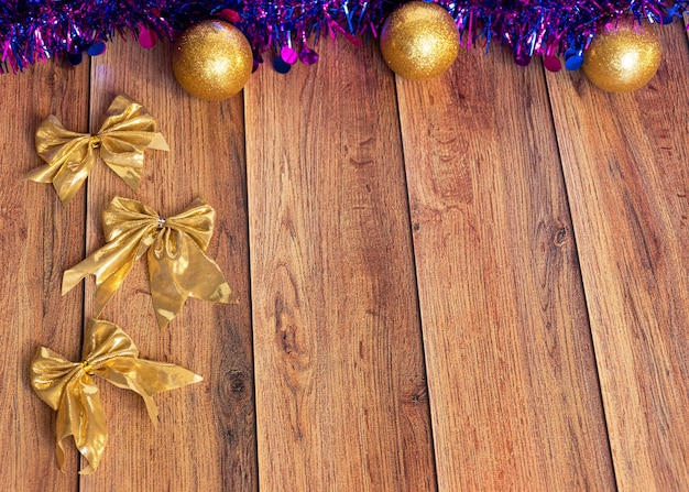 I regali sono confezionati in carta kraft e legati con un nastro di raso con giocattoli di Natale e orpelli viola su sfondo di legno Decorazione per l'albero di Natale