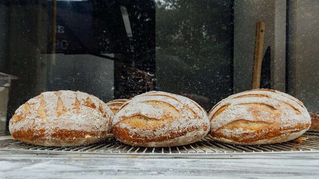 I rotoli di pane appena sfornati e caldi si trovano sul bancone di marmo superiore per la vendita.