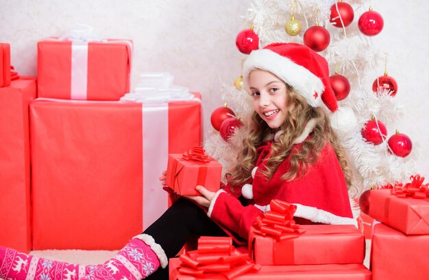 I sogni diventano realtà. Concetto di felicità invernale. Disimballaggio del regalo di Natale. Esplora i regali di Natale. Miracolo invernale. Bambino entusiasta del regalo di Natale. La ragazza celebra il natale. Babbo Natale porta il suo regalo.