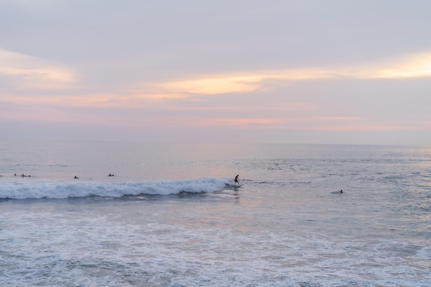 I surfisti catturano le onde al tramonto nell'oceano. Sfondo di surf