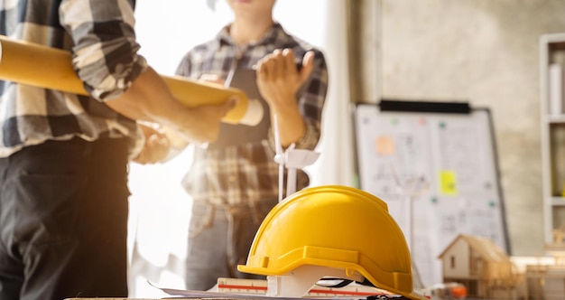 I team di ingegneri che si incontrano lavorando insieme indossano caschi protettivi da lavoratore in cantiere nella città modernaTeam di professionisti dell'industria asiatica