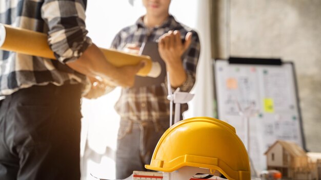 I team di ingegneri che si incontrano lavorando insieme indossano caschi protettivi da lavoratore in cantiere nella città modernaTeam di professionisti dell'industria asiatica