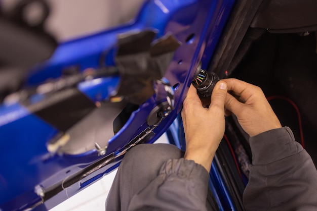 I tecnici di riparazione auto nelle officine di riparazione auto riparano i sistemi delle portiere delle auto e riparano i sistemi dei veicoli elettrici.
