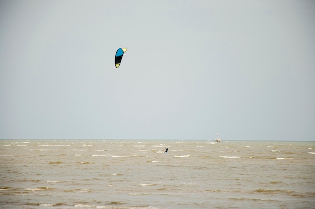 I thailandesi giocano a Kite Surf con vento e onde sul mare alla spiaggia di Laem Charoen e alla spiaggia di Mae Pim a Rayong Thailandia