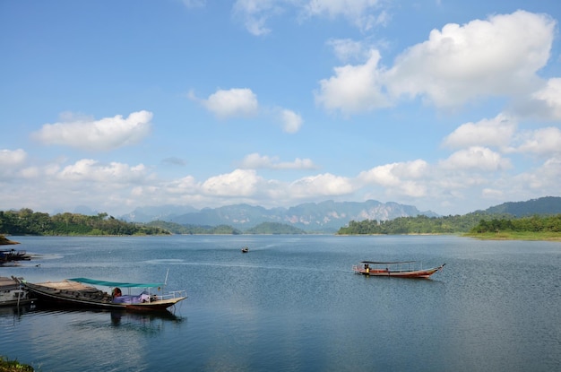 I thailandesi navigano in barca a coda lunga per l'invio e la ricezione di persone che viaggiano nel lago Cheow Lan a Ratchaprapa o nel bacino idrico della diga di Rajjaprabha nel Parco nazionale di Khao Sok nella provincia di Surat Thani in Thailandia