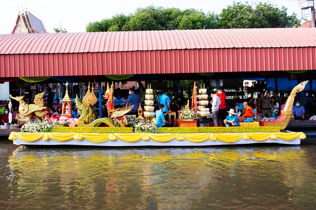 I thailandesi viaggiatori stranieri visitano e si uniscono alla tradizione meritano rituali e pregano offrendo l'elemosina alla processione dei monaci sulla barca nel canale di Wat Sai Yai l'8 novembre 2022 a Nonthaburi Thailandia