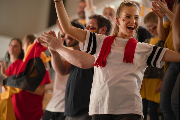 I tifosi di calcio appoggiano la squadra nazionale tedesca in diretta nella partita di calcio allo stadio