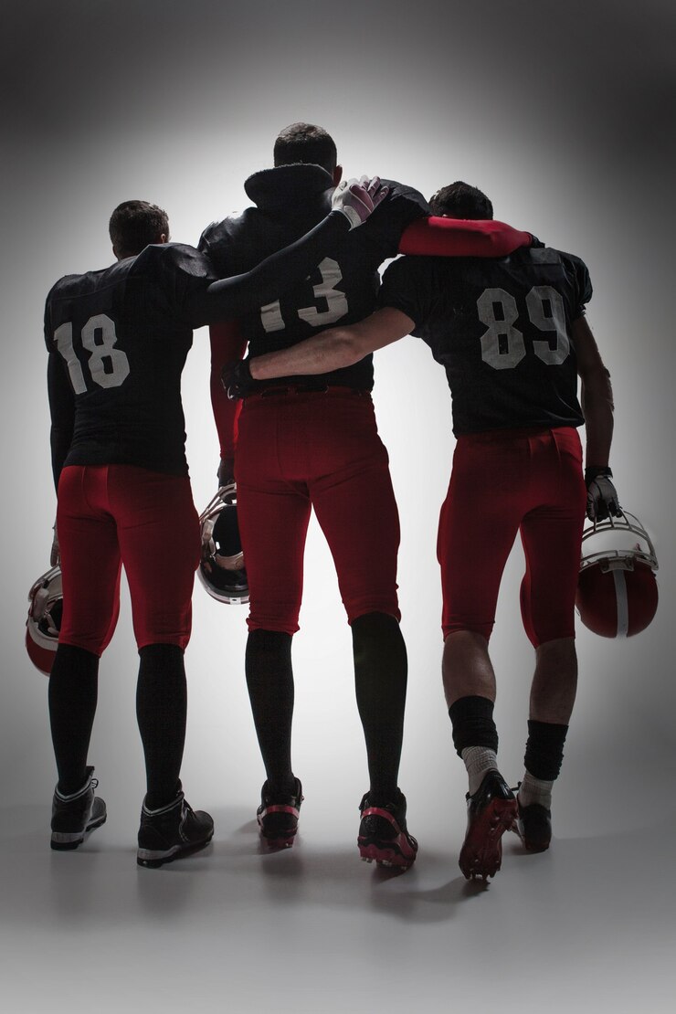 Foto i tre giocatori di football americano su sfondo grigio