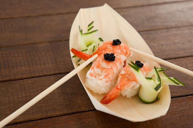 I tre sushi di nigiri sono servito con le bacchette in zolla di legno della barca