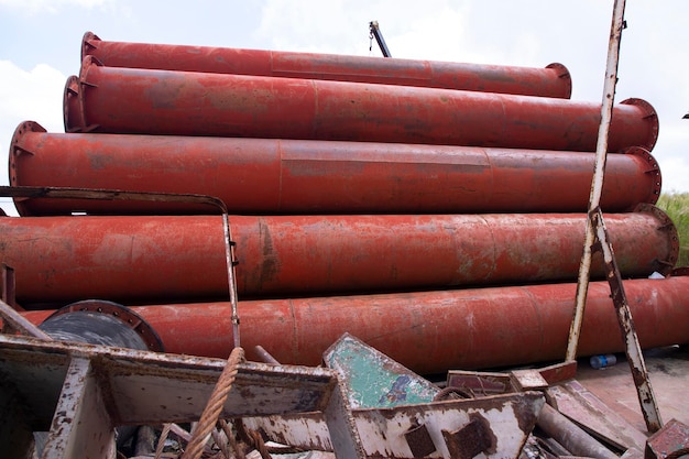 I tubi metallici in acciaio di ferro arrugginito impilano un campo industriale