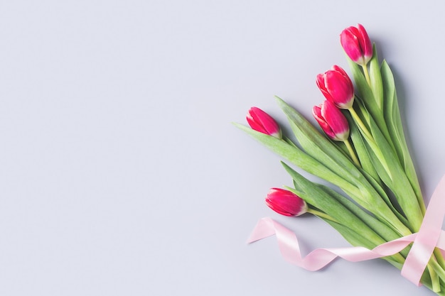 I tulipani sono piatti con fiori rosa e bianchi su sfondo blu Spazio per la copia della vista dall'alto