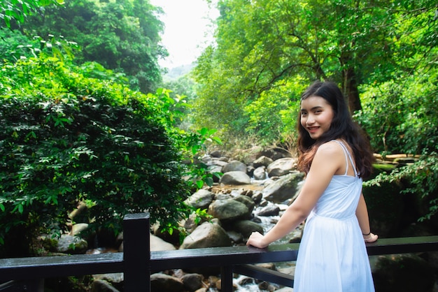 I turisti asiatici della ragazza visitano la bellezza della natura nel segno del parco nazionale della cascata di Phlio a Chanthaburi, Tailandia.