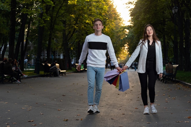 I turisti camminano nel parco e tengono in mano sacchetti di carta con souvenir e regali.