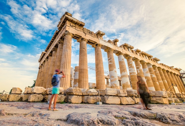 I turisti che fotografano le rovine delle colonne di marmo del Partenone