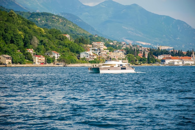 I turisti del MONTENEGRO KAMENARI nuotano nella baia di Boka Kotorska su un catamarano a motore