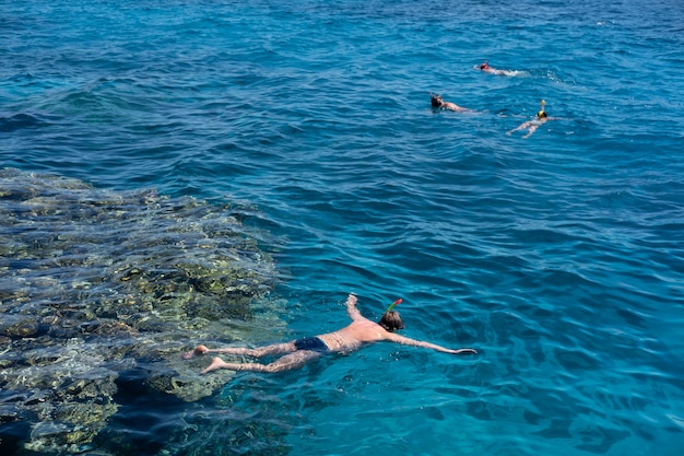 I turisti fanno snorkeling in acque turchesi cristalline