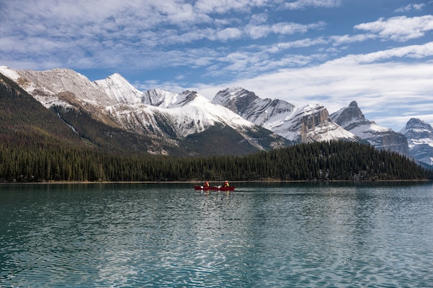 I turisti in canoa nell'isola dello spirito con le Montagne Rocciose Canadesi sul lago Maligne al Parco Nazionale di Jasper, AB, Canada