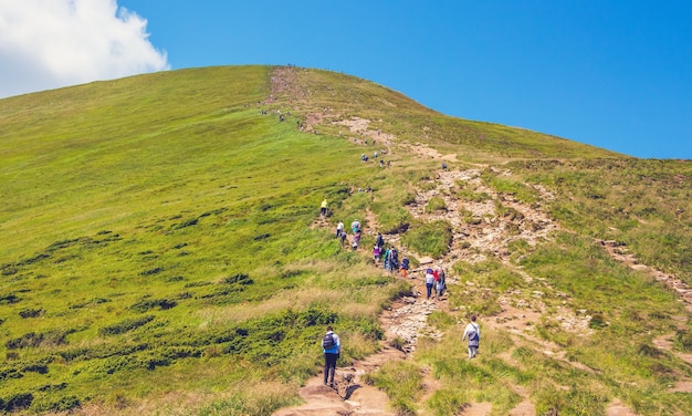 I turisti salgono la montagna su un ripido sentiero roccioso. Conquista della montagna