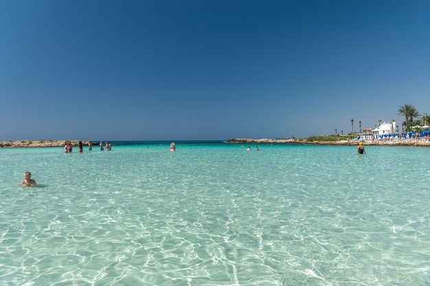 I turisti si rilassano e nuotano su una delle spiagge più famose dell'isola.