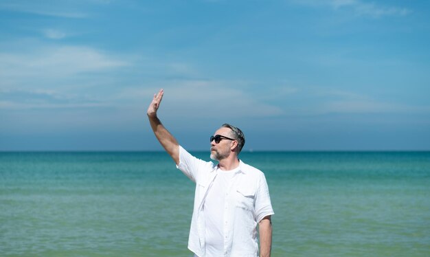 I turisti stranieri passeggiano lungo la bellissima spiaggia del mare blu dell'Asia