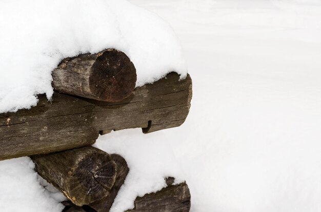 I vecchi tronchi rotondi accatastati mucchio coperto di neve. Spazio vuoto per i tuoi appunti.